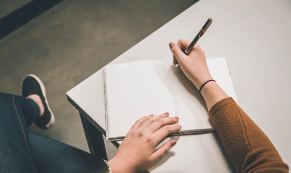 A person writing notes in an open notebook